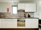 Thumbnail 13 of 39 - a kitchen with white cabinets and a window