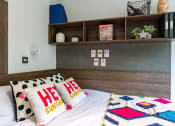 Thumbnail 15 of 39 - a bedroom with a bed and a shelf on the wall