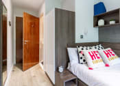 Thumbnail 16 of 39 - a bedroom with a bed and a wardrobe
