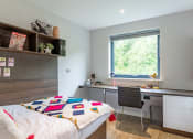 Thumbnail 20 of 39 - a bedroom with a bed and a desk
