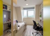 Thumbnail 16 of 50 - a bedroom with a bed and desk in a 555 waverly unit