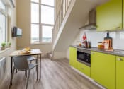 Thumbnail 38 of 50 - a kitchen with green cabinets and a table and chairs