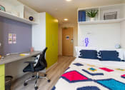 Thumbnail 22 of 50 - a bedroom with a bed and desk in a 555 waverly unit