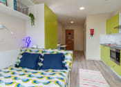 Thumbnail 37 of 50 - a bedroom with green cabinets and a yellow and blue bedspread
