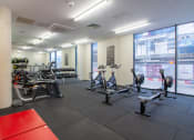 Thumbnail 9 of 50 - a spacious fitness room with cardio equipment and a large window with a view of the city