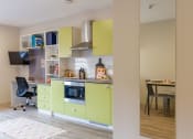 Thumbnail 44 of 50 - a small kitchen with green cabinets and a desk