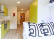 Thumbnail 34 of 50 - a bedroom with green cabinets and a white bed
