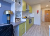 Thumbnail 27 of 50 - a kitchen with green cabinets and blue walls