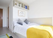 Thumbnail 22 of 49 - a bedroom with a bed and a yellow blanket