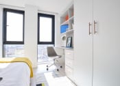 Thumbnail 23 of 49 - a bedroom with a desk and a window