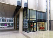 Thumbnail 48 of 49 - a building with a large glass door and a street in the background