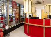 Thumbnail 43 of 49 - a red reception desk sitting next to a window