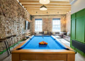 Thumbnail 1 of 49 - a game room with a pool table and brick walls