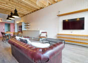 Thumbnail 5 of 49 - a living room with a brown leather couch and a flat screen tv on the wall