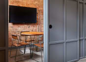 Thumbnail 15 of 49 - a room with a table and chairs and a television on the wall