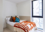 Thumbnail 34 of 49 - a bedroom with white walls and a large window