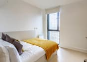 Thumbnail 27 of 49 - a bedroom with a bed and a window