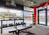 Thumbnail 7 of 51 - An on-site gym with a bench and dumbells
