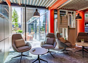 Thumbnail 14 of 51 - Chill-out area with comfortable chairs with pillows and a small round table. Nearby to a large window looking out onto the courtyard.