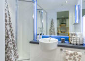 Thumbnail 27 of 51 - En-suite bathroom with large mirror, shower and sink.