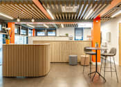 Thumbnail 37 of 51 - Bright reception space with brown panelling, stools and a high table.