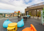 Thumbnail 47 of 51 - A patio with bean bag chairs and tables.