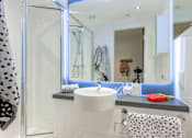 Thumbnail 5 of 48 - A white sink in a bathroom with a mirror above it.
