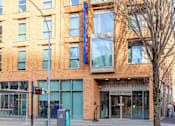 Thumbnail 21 of 48 - A brick building with a sign that says "Student Living Reception.".