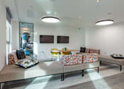 Thumbnail 25 of 48 - A modern living room with a grey sofa and a yellow chair.