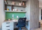 Thumbnail 32 of 48 - A black office chair is in front of a desk with a green board behind it.