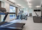 Thumbnail 39 of 48 - A gym with treadmills, exercise bikes, and other equipment.