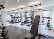 Thumbnail 42 of 48 - A gym with a variety of equipment including treadmills, weights, and exercise machines.
