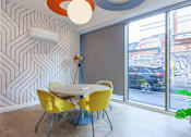 Thumbnail 44 of 48 - A dining room with a white table and yellow chairs.