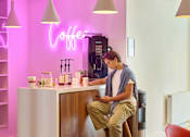 Thumbnail 25 of 62 - A person is sitting on a counter in a coffee shop.