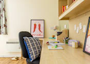 Thumbnail 33 of 35 - A room with a chair and a table with a picture of two chili peppers on the wall.