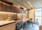 Thumbnail 4 of 7 - a kitchen with wooden cabinets and a table with chairs