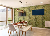 Thumbnail 6 of 21 - A dining room with a table set for two and a wallpapered green wall.