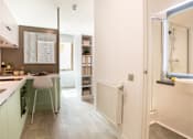 Thumbnail 15 of 21 - A white and green kitchen with a white chair and a white radiator.