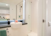 Thumbnail 16 of 21 - A white sink with a green towel hanging on the wall.
