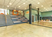 Thumbnail 12 of 33 - the lobby of a building with a staircase and tables and chairs