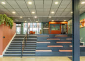 Thumbnail 13 of 33 - the lobby of a building with blue steps and orange walls