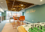 Thumbnail 3 of 33 - a game room with a foosball table and chairs