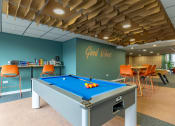 Thumbnail 4 of 33 - a pool table in a room with a bar and chairs