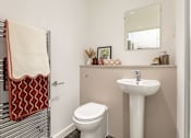 Thumbnail 14 of 59 - a bathroom with orange towel, toilet, sink and mirror