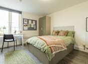 Thumbnail 6 of 59 - bed with green bedding and a desk with a chair