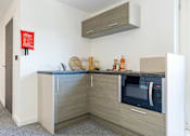 Thumbnail 23 of 59 - studio kitchenette with oven and storage
