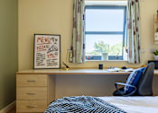 Thumbnail 31 of 35 - A room with a bed, desk, and a menu board on the wall.