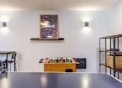 Thumbnail 7 of 35 - A table with a foosball table in the middle of the room.