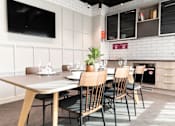 Thumbnail 3 of 23 - A modern dining area with a long table and chairs.