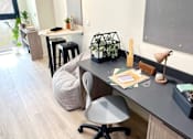 Thumbnail 18 of 23 - A modern home office with a grey desk, a grey chair, and a grey bean bag.